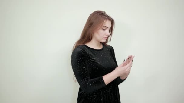 Girl brown haired in black dress over isolated white background shows emotions — Stock Video