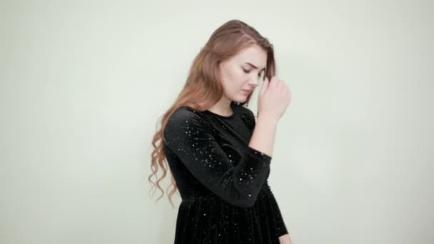 Chica de cabello castaño en vestido negro sobre fondo blanco aislado muestra emociones — Vídeos de Stock
