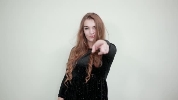 Дівчина коричневе волосся в чорній сукні над ізольованим білим тлом показує емоції — стокове відео