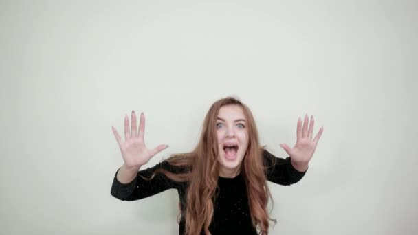 Girl brown haired in black dress over isolated white background shows emotions — Stock Video