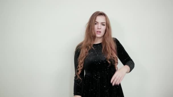 Mädchen mit braunen Haaren in schwarzem Kleid über isoliertem weißem Hintergrund zeigt Emotionen — Stockvideo