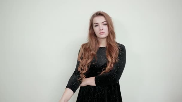 Girl brown haired in black dress over isolated white background shows emotions — Stock Video