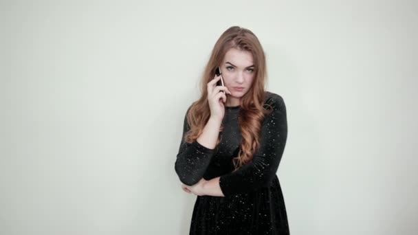 Girl brown haired in black dress over isolated white background shows emotions — Stock Video