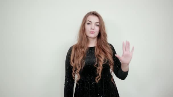 Mädchen mit braunen Haaren in schwarzem Kleid über isoliertem weißem Hintergrund zeigt Emotionen — Stockvideo