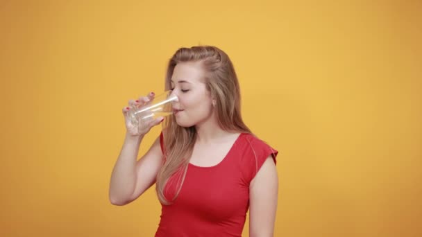 Giovane ragazza bionda in t-shirt rossa su sfondo arancione isolato mostra emozioni — Video Stock