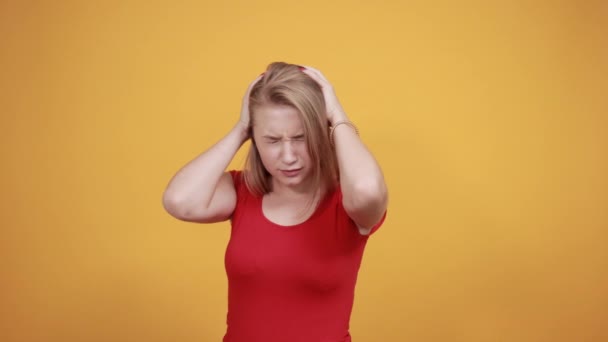 Jovem loira menina em vermelho t-shirt sobre isolado laranja fundo mostra emoções — Vídeo de Stock