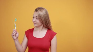 izole turuncu arka plan üzerinde kırmızı t-shirt genç sarışın kız duygularını gösterir