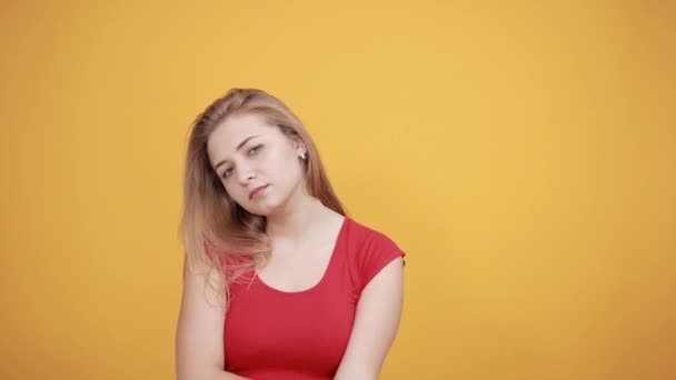 Jovem loira menina em vermelho t-shirt sobre isolado laranja fundo mostra emoções — Vídeo de Stock