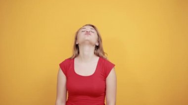 izole turuncu arka plan üzerinde kırmızı t-shirt genç sarışın kız duygularını gösterir