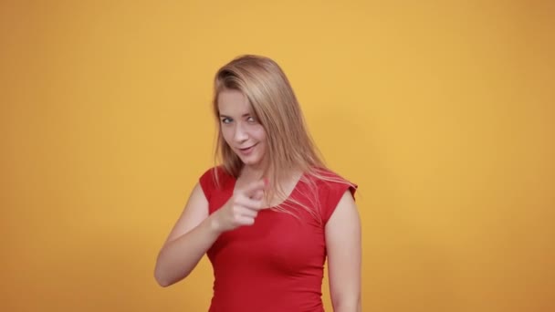 Junges blondes Mädchen in rotem T-Shirt über orangefarbenem Hintergrund zeigt Emotionen — Stockvideo