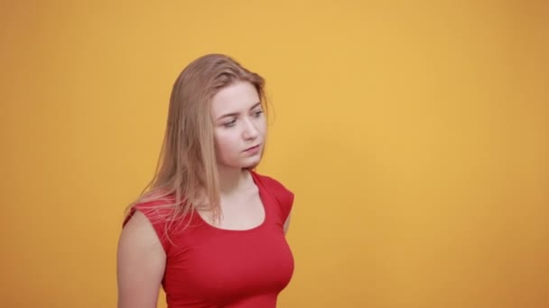 Joven rubia chica en rojo camiseta sobre aislado naranja fondo muestra emociones — Vídeos de Stock