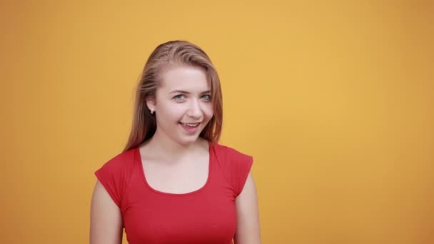 Jovem loira menina em vermelho t-shirt sobre isolado laranja fundo mostra emoções — Vídeo de Stock