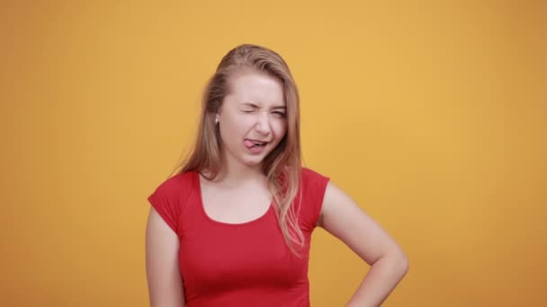 Joven rubia chica en rojo camiseta sobre aislado naranja fondo muestra emociones — Vídeos de Stock