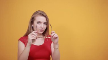 izole turuncu arka plan üzerinde kırmızı t-shirt genç sarışın kız duygularını gösterir