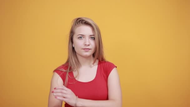 Joven rubia chica en rojo camiseta sobre aislado naranja fondo muestra emociones — Vídeos de Stock