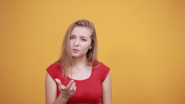 Jovem loira menina em vermelho t-shirt sobre isolado laranja fundo mostra emoções — Vídeo de Stock