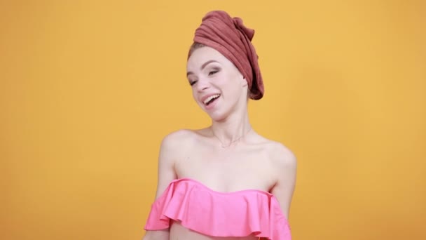 Fiatal lány törölköző a feje fölött elkülönített narancssárga háttér mutatja érzelmek — Stock videók