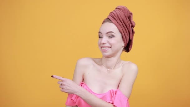 Jong meisje met handdoek op haar hoofd over geïsoleerde oranje achtergrond toont emoties — Stockvideo