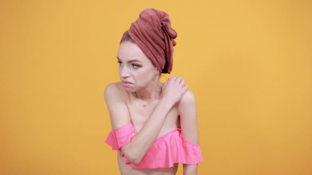 Молодая девушка с полотенцем на голове на изолированном оранжевом фоне показывает эмоции — стоковое видео