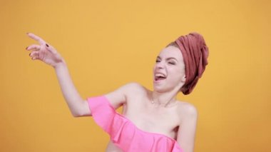 izole turuncu arka plan üzerinde kafasına havlu ile genç kız duygularını gösterir