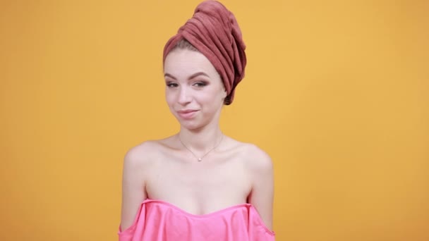 Junges Mädchen mit Handtuch auf dem Kopf vor isoliertem orangefarbenem Hintergrund zeigt Emotionen — Stockvideo