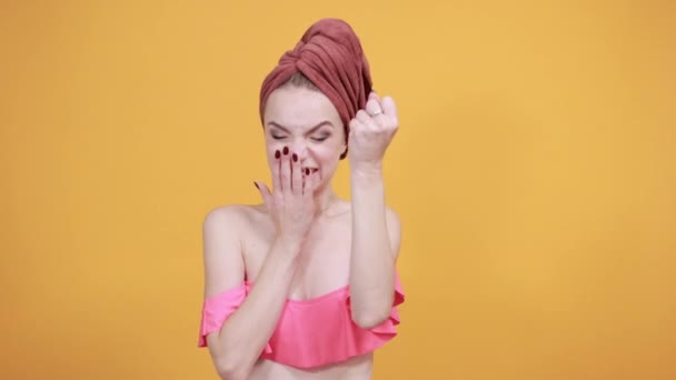 Fiatal lány törölköző a feje fölött elkülönített narancssárga háttér mutatja érzelmek — Stock videók