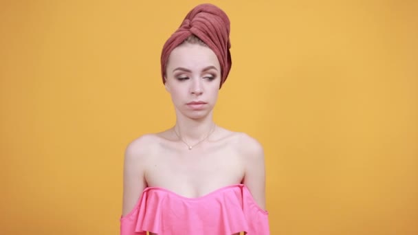 Junges Mädchen mit Handtuch auf dem Kopf vor isoliertem orangefarbenem Hintergrund zeigt Emotionen — Stockvideo