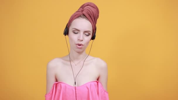 Młoda dziewczyna z ręcznikiem na głowie na białym tle pomarańczowe pokazuje emocje — Wideo stockowe