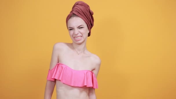 Chica joven con toalla en la cabeza sobre fondo naranja aislado muestra emociones — Vídeos de Stock