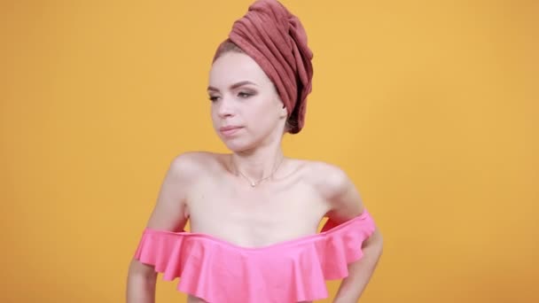 Young girl with towel on her head over isolated orange background shows emotions — Stock Video