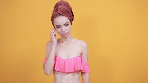 Jeune fille avec serviette sur la tête sur fond orange isolé montre des émotions — Video