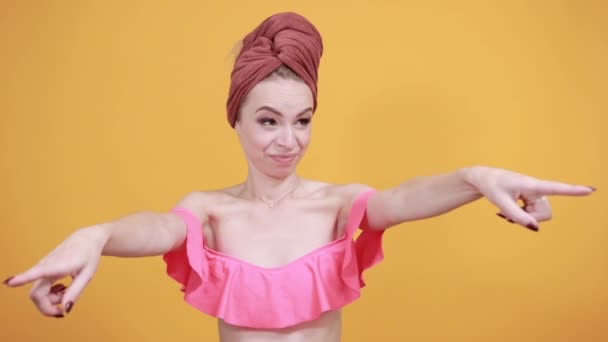 Młoda dziewczyna z ręcznikiem na głowie na białym tle pomarańczowe pokazuje emocje — Wideo stockowe