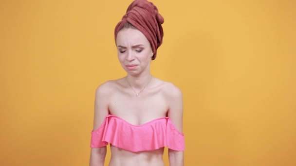 Chica joven con toalla en la cabeza sobre fondo naranja aislado muestra emociones — Vídeo de stock