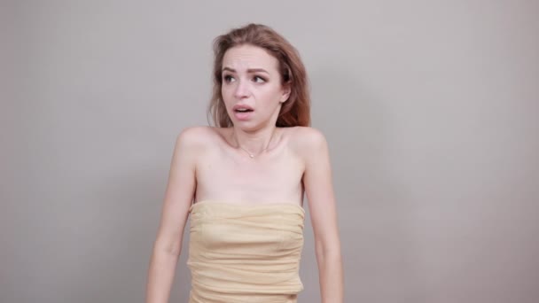 Hermosa chica en camiseta beige sobre fondo blanco aislado muestra emociones — Vídeo de stock