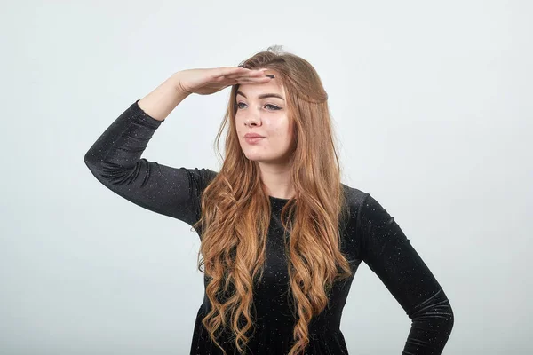 Chica de cabello castaño en vestido negro sobre fondo blanco aislado muestra emociones —  Fotos de Stock