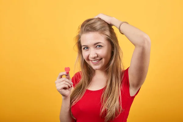 Joven rubia chica en rojo camiseta sobre aislado naranja fondo muestra emociones —  Fotos de Stock