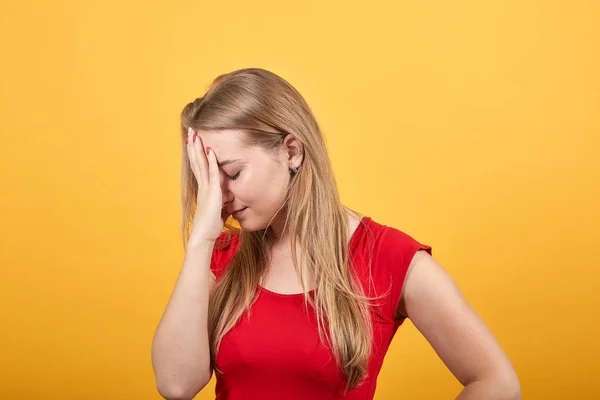 Jong blond meisje in rood t-shirt over geïsoleerde oranje achtergrond toont emoties — Stockfoto