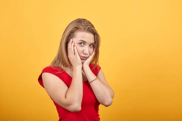 Joven rubia chica en rojo camiseta sobre aislado naranja fondo muestra emociones — Foto de Stock