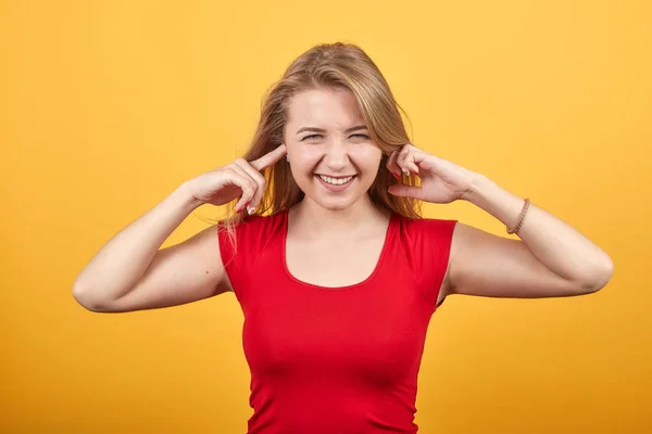 Junges blondes Mädchen in rotem T-Shirt über orangefarbenem Hintergrund zeigt Emotionen — Stockfoto