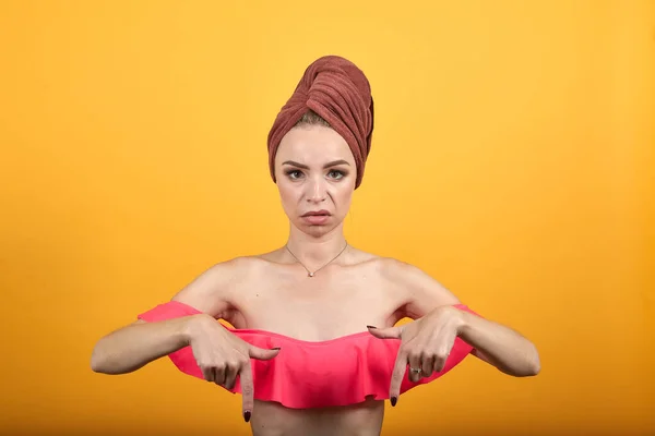 Chica joven con toalla en la cabeza sobre fondo naranja aislado muestra emociones —  Fotos de Stock