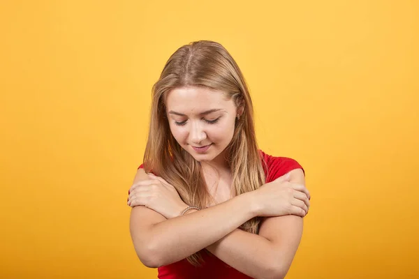 Jong blond meisje in rood t-shirt over geïsoleerde oranje achtergrond toont emoties — Stockfoto