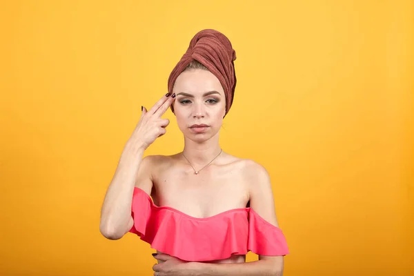 Chica joven con toalla en la cabeza sobre fondo naranja aislado muestra emociones — Foto de Stock