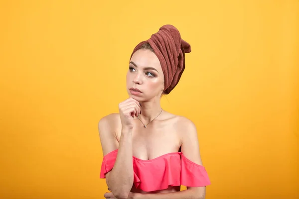 Chica joven con toalla en la cabeza sobre fondo naranja aislado muestra emociones — Foto de Stock