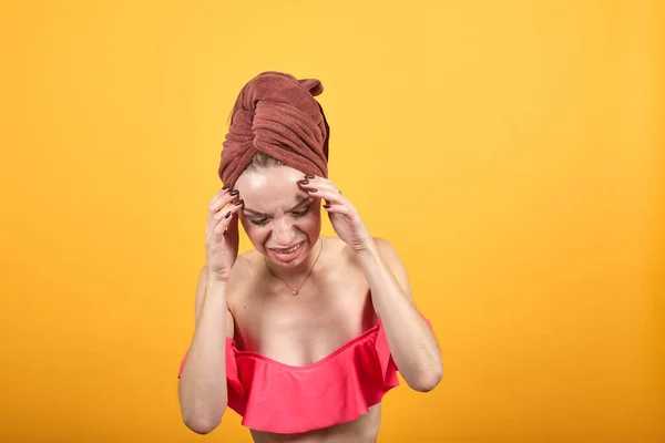 Молода дівчина з рушником на голові над ізольованим помаранчевим тлом показує емоції — стокове фото