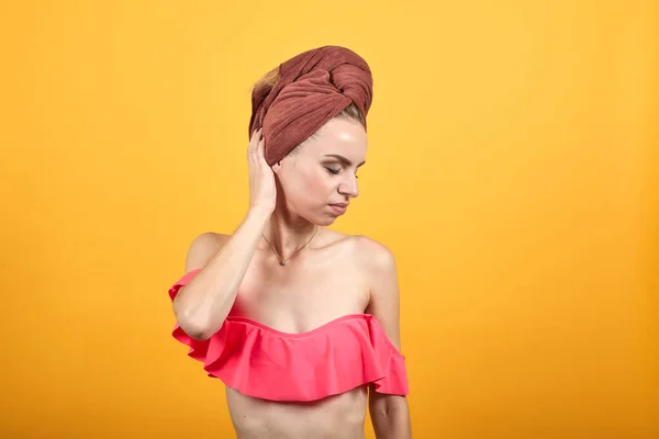 Chica joven con toalla en la cabeza sobre fondo naranja aislado muestra emociones —  Fotos de Stock