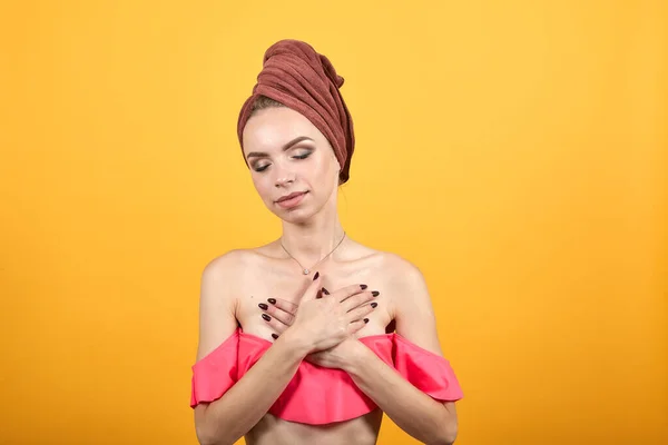 Chica joven con toalla en la cabeza sobre fondo naranja aislado muestra emociones —  Fotos de Stock