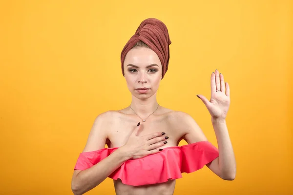 Chica joven con toalla en la cabeza sobre fondo naranja aislado muestra emociones —  Fotos de Stock