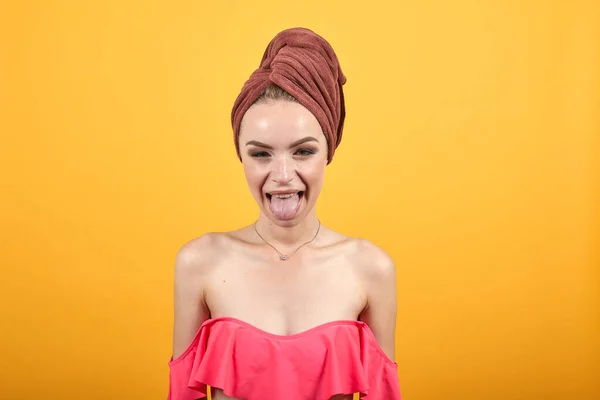 Νεαρό κορίτσι με πετσέτα στο κεφάλι της πάνω από απομονωμένο πορτοκαλί φόντο δείχνει τα συναισθήματα — Φωτογραφία Αρχείου