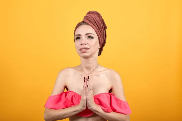 Chica joven con toalla en la cabeza sobre fondo naranja aislado muestra emociones —  Fotos de Stock