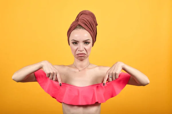 Chica joven con toalla en la cabeza sobre fondo naranja aislado muestra emociones —  Fotos de Stock